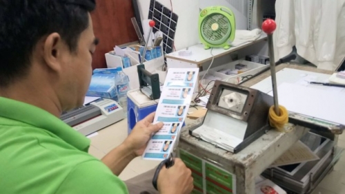 Nhân viên In Thẻ Nhựa đang tiến hành gia công cắt viền thừa cho thẻ nhựa của khách đặt in 