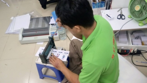 Thợ gia công In Thẻ Nhựa đang thực hiện đục lỗ 4 góc cho thẻ nhựa các loại sau in trước khi chuyển thẻ qua công đoạn bế thành phẩm